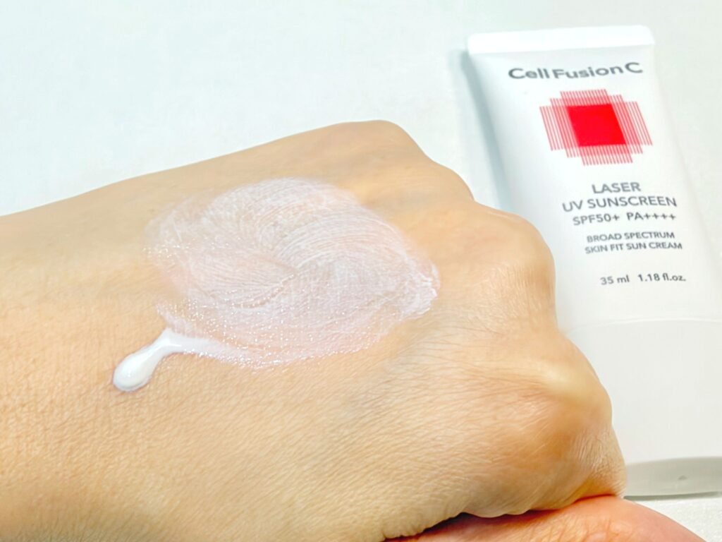 Cell Fusion C Laser Sunscreen 100 swatched on the back of a hand with half left unblended and half smoothly spread to show its lightweight hybrid SPF texture