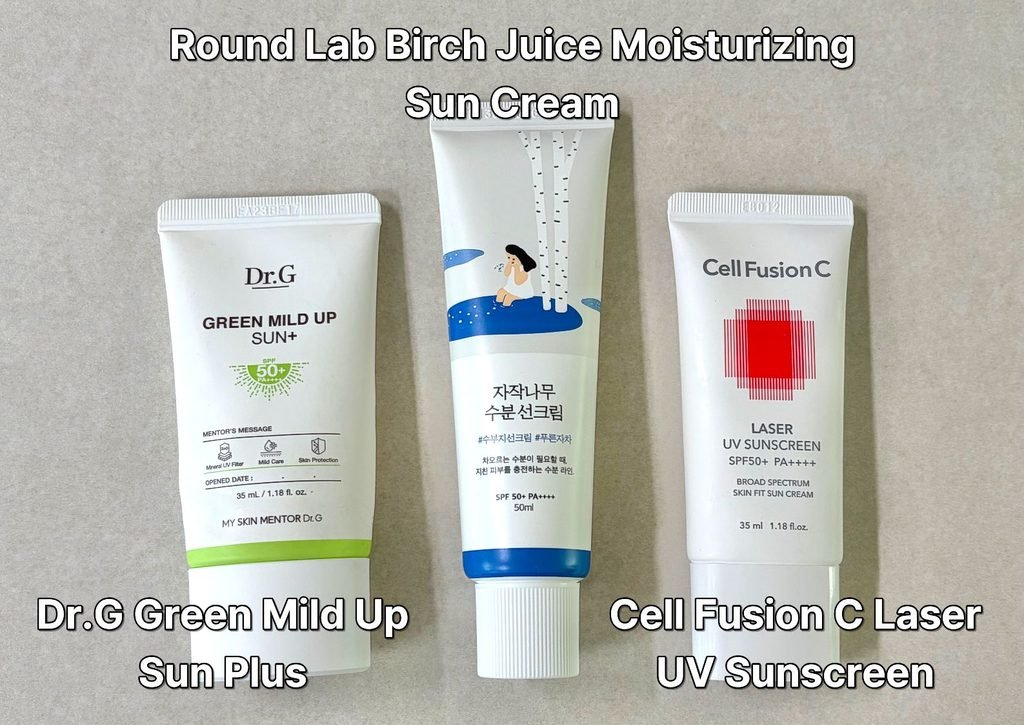 Group shot of Dr.G Green Mild Up Sun Plus, Cell Fusion C Laser UV Sunscreen, and Round Lab Birch Juice Moisturizing Sun Cream packaging and tubes lined up as a thumbnail for a K-beauty sunscreen comparison review.