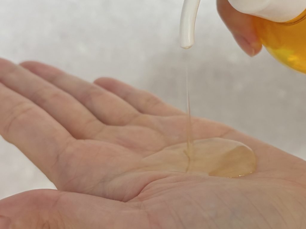 Lightweight and runny watery texture of Manyo Pure Cleansing Oil pumped onto a palm.