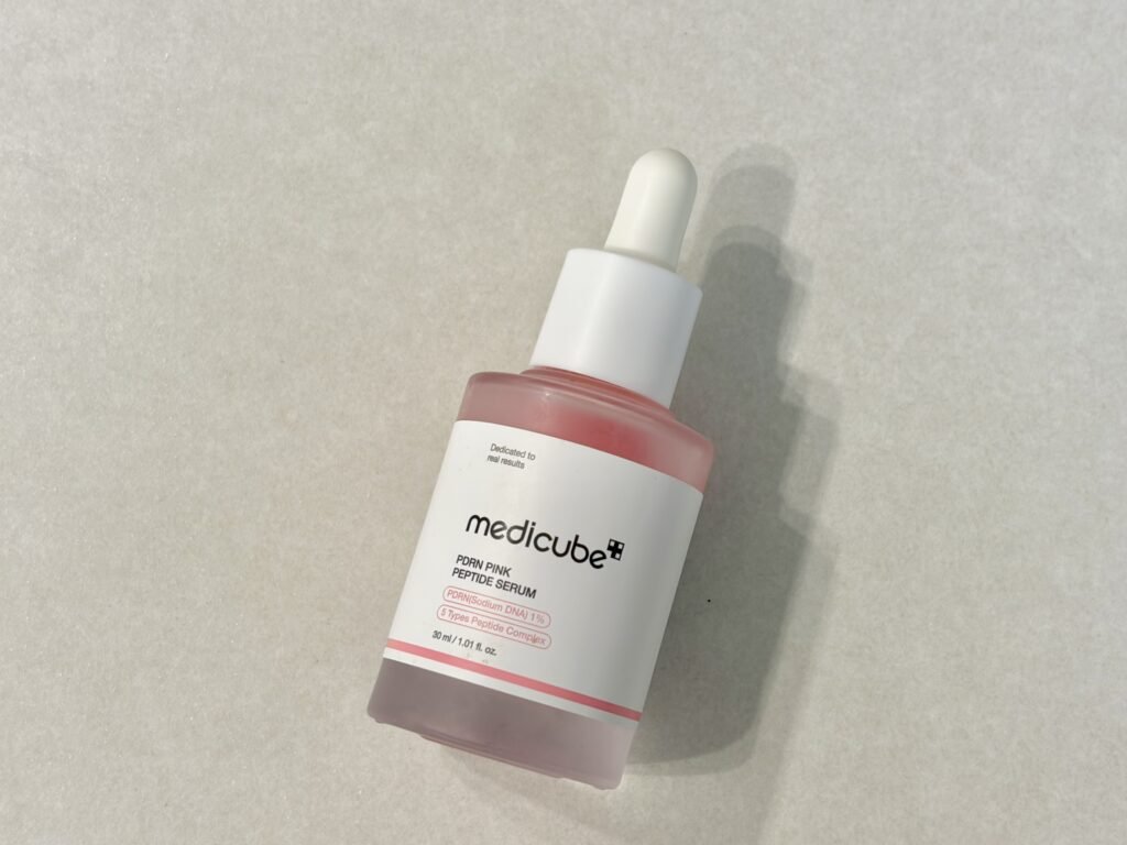 Medicube PDRN Pink Peptide Ampoule bottle on a minimal aesthetic surface