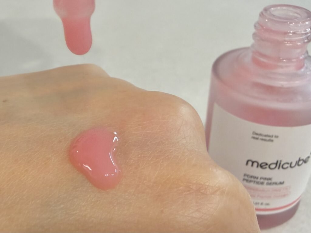 Elastic pink droplet texture of Medicube PDRN Pink Peptide Ampoule for skin regeneration and plumping.