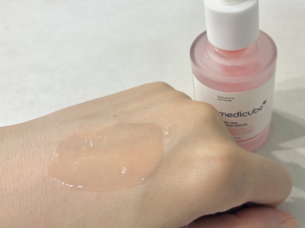 Spreading the natural pink vitamin B12 gel texture of Medicube PDRN ampoule