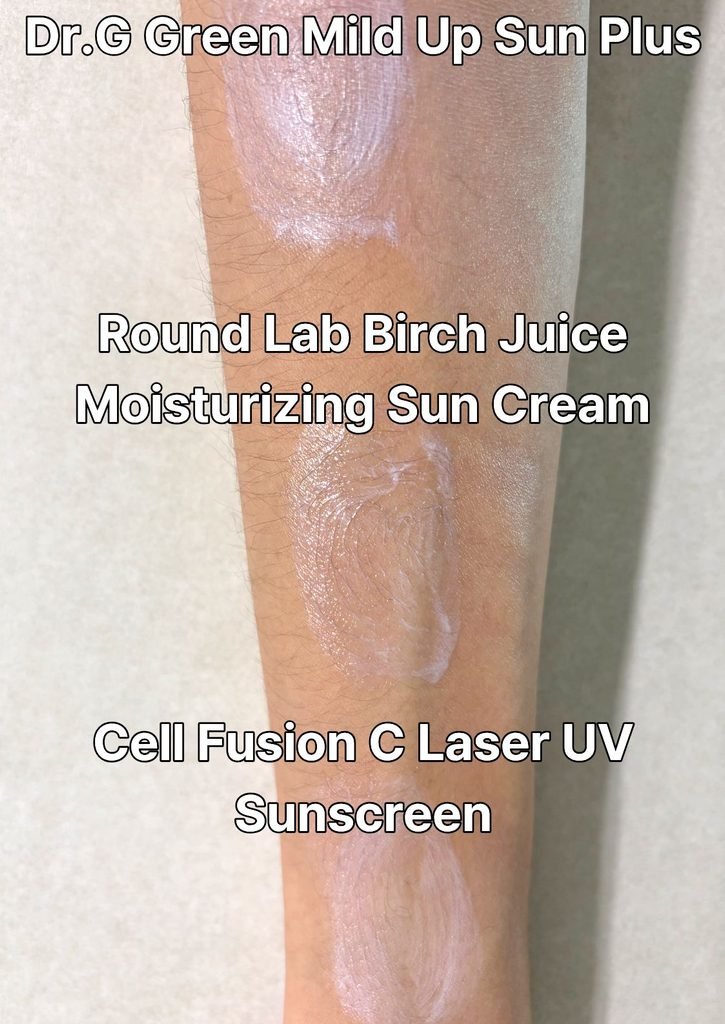 A close-up view comparing the final finish of Dr.G (matte, subtle white cast), Cell Fusion C (natural glow), and Round Lab (dewy, zero white cast) sunscreens fully blended onto the forearm.